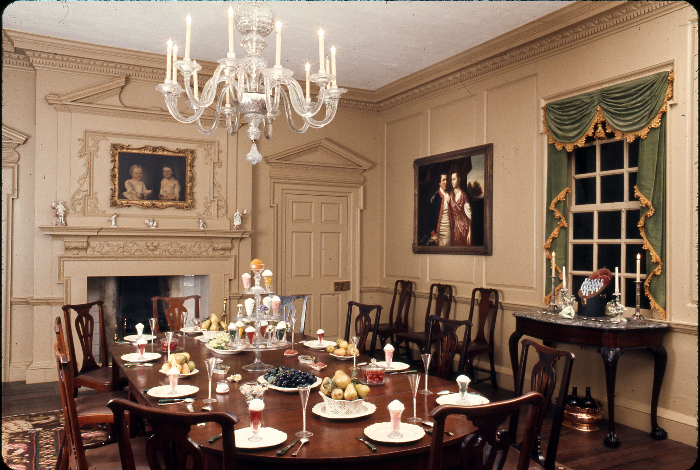 Color photograph of a finely furnished dining room with a large set table at center.
