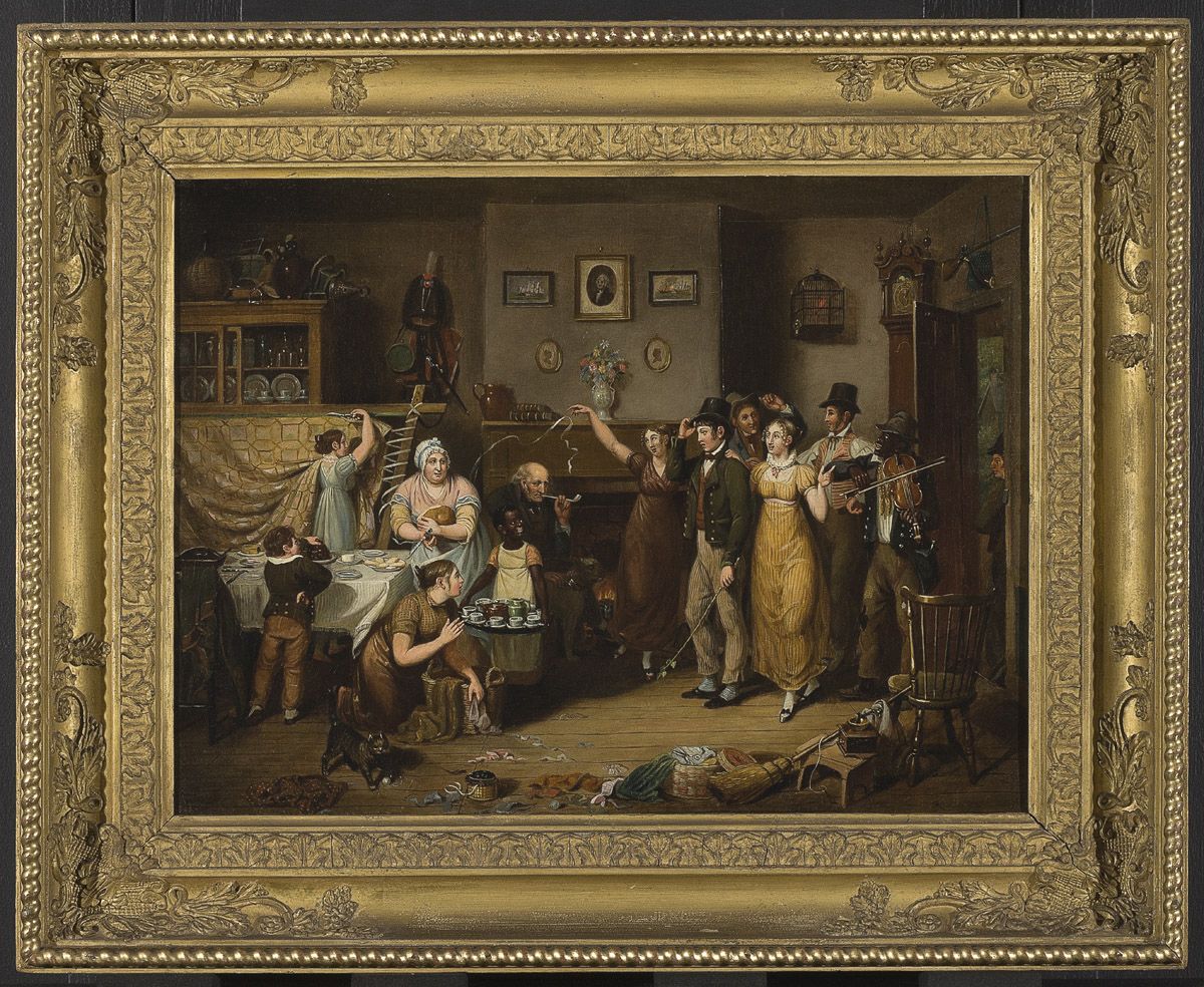 A painting of a domestic scene of a room filled with several figures. The right side of the room has a group of people entering through a door, moving into the center of the painting. Five of these figures are light-skinned, wearing fine clothing. The other figure in this party has dark skin, wears a hat, and is playing a fiddle. On the left side of the painting there are five other figures. An elderly light-skinned man sits towards the center in front of a fireplace, smoking a pipe. In front of him there is a young dark-skinned girl, smiling up at the group of people entering. She is wearing an orange dress covered by a white apron and is holding a tray of ceramic cups. Immediately to the left there is a light-skinned woman wearing a white cap and pink dress, holding a plate. On her other side there is a light-skinned, brown-haired young woman cutting yellow fabric from a wooden frame. There is a table in front of her, covered with dishes and food. A young, light-skinned boy with his back to the viewer is taking food from the table. From under the table, a light-skinned, brown-haired woman emerges, holding a basket of fabric and looking up at the party. The room is decorated with many paintings, a bird cage, and clock. The back-left corner has a cupboard filled with dishes, with more dishes piled on top of it. In the right and center foreground, there are many objects scattered, including a chair, broom, and fabric. A small dark cat is in the left foreground. The painting is in a golden frame.